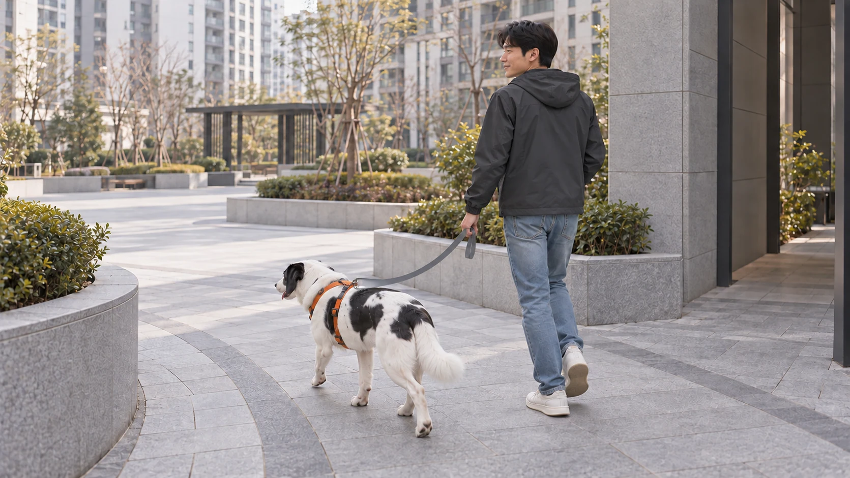 좁은 건물 사이 길에서 넓은 마당 쪽으로 걸어 나오는 보호자와 개