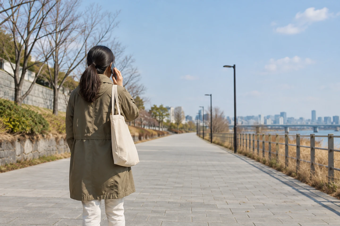 넓은 산책로에서 휴대전화로 통화하는 사람