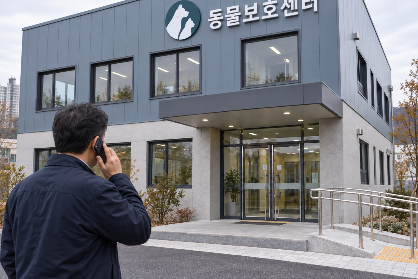 보호센터 입구를 바라보는 성인 남성의 어깨 너머 장면