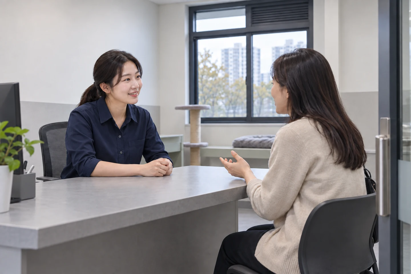방문자와 담당자가 테이블에서 대화하는 장면